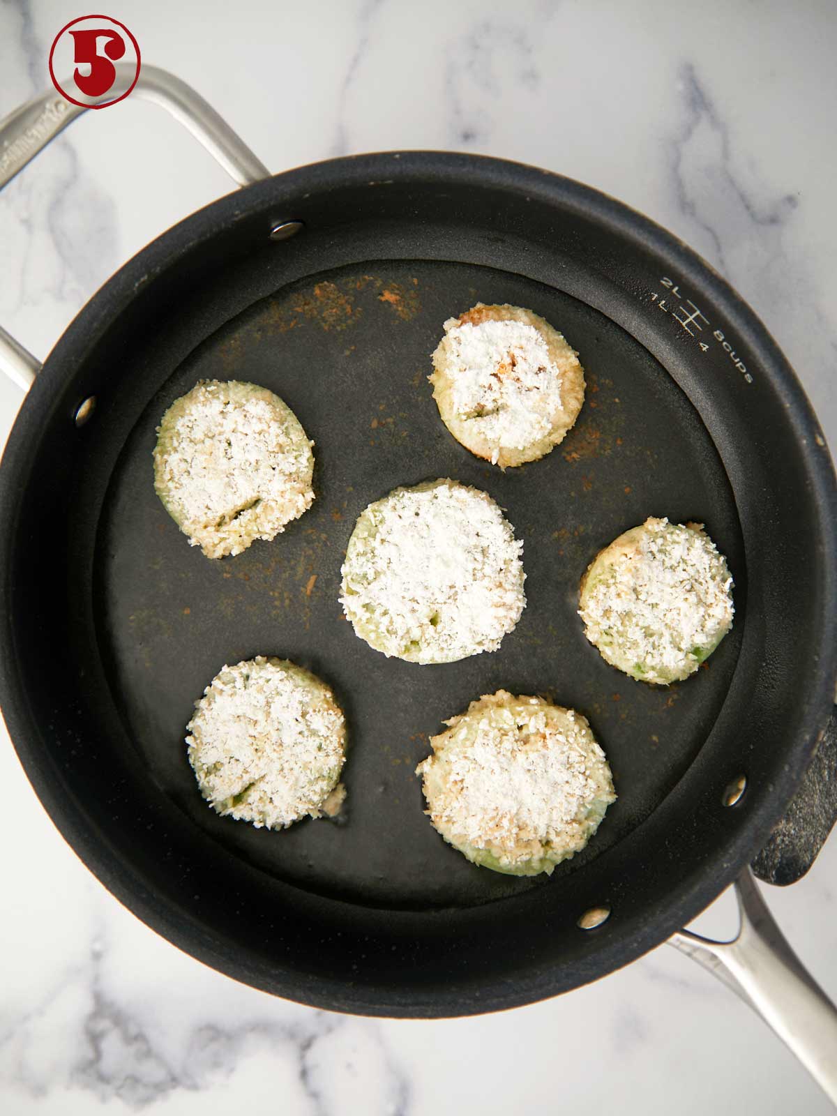 Green tomatoes frying in oil.