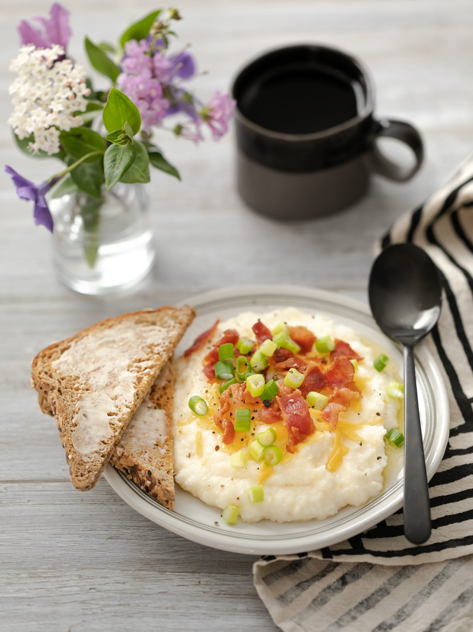 Table setting with plate of Savory Breakfast Grits with coffee and toast.