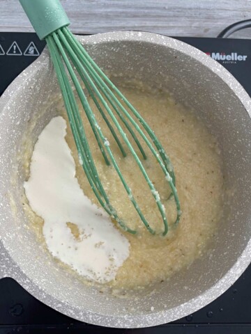 Cream being added to the pot of grits.