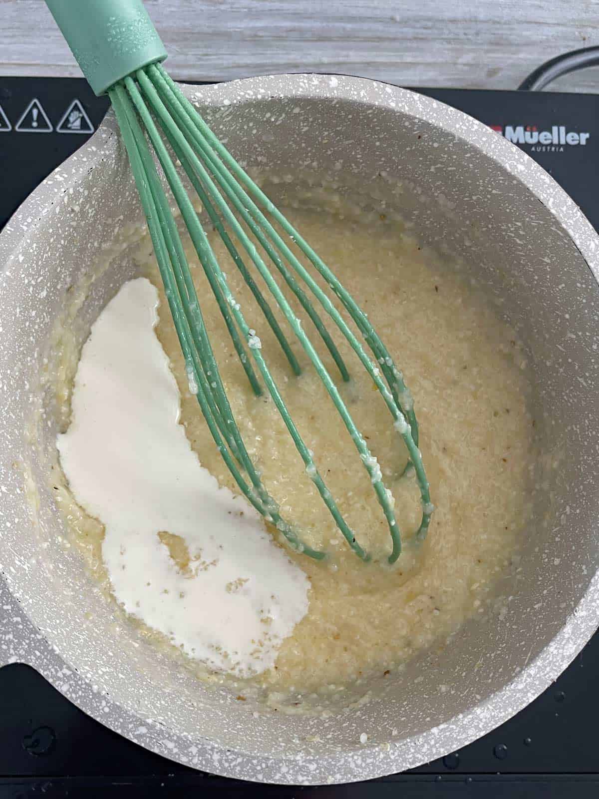 Cream being added to the pot of grits.