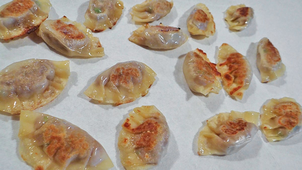 Asian style dumplings on a white sheet of paper.