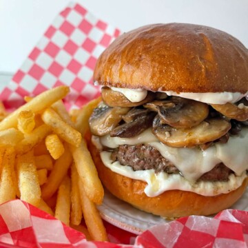 Mushroom Swiss Burger in red checked paper-lined basket with fries.