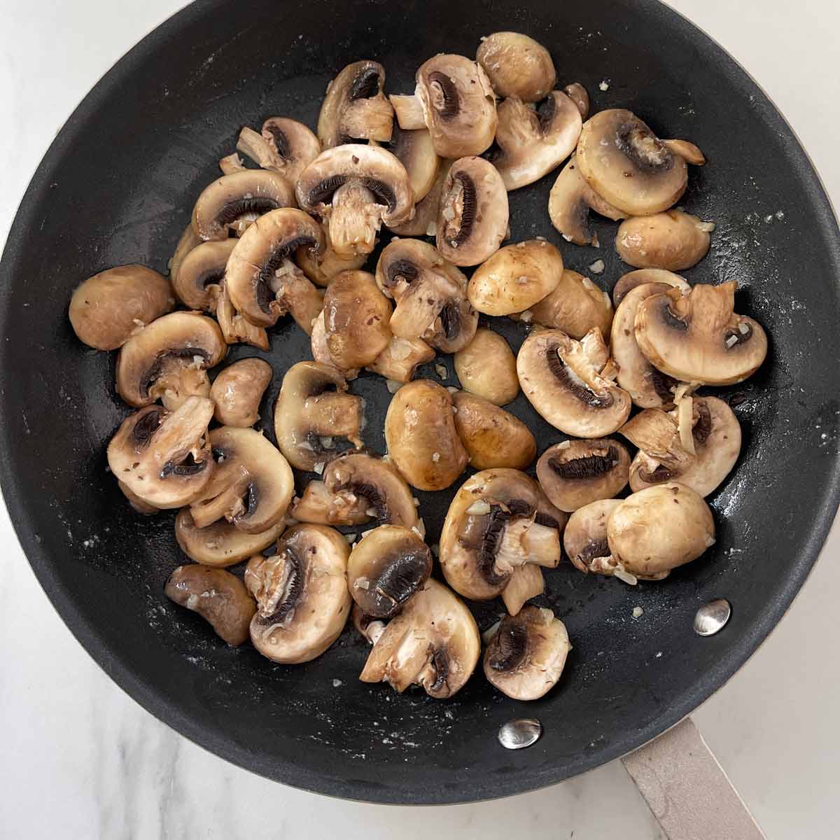 Mushrooms in a skillet with garlic butter.