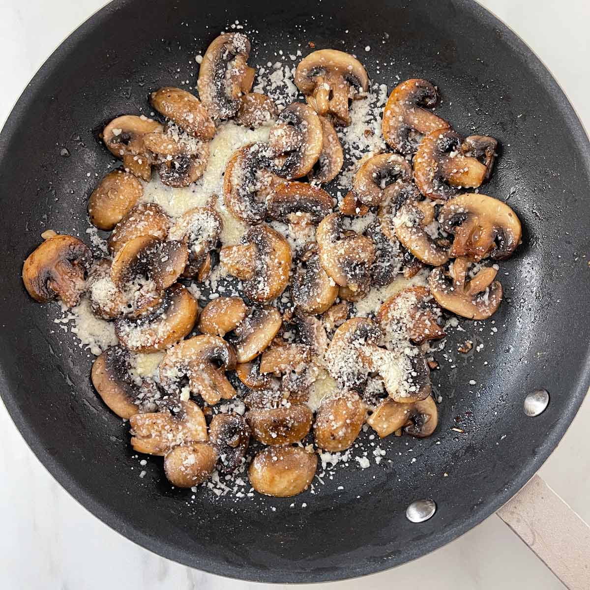 Parmesan cheese on cooked mushrooms.
