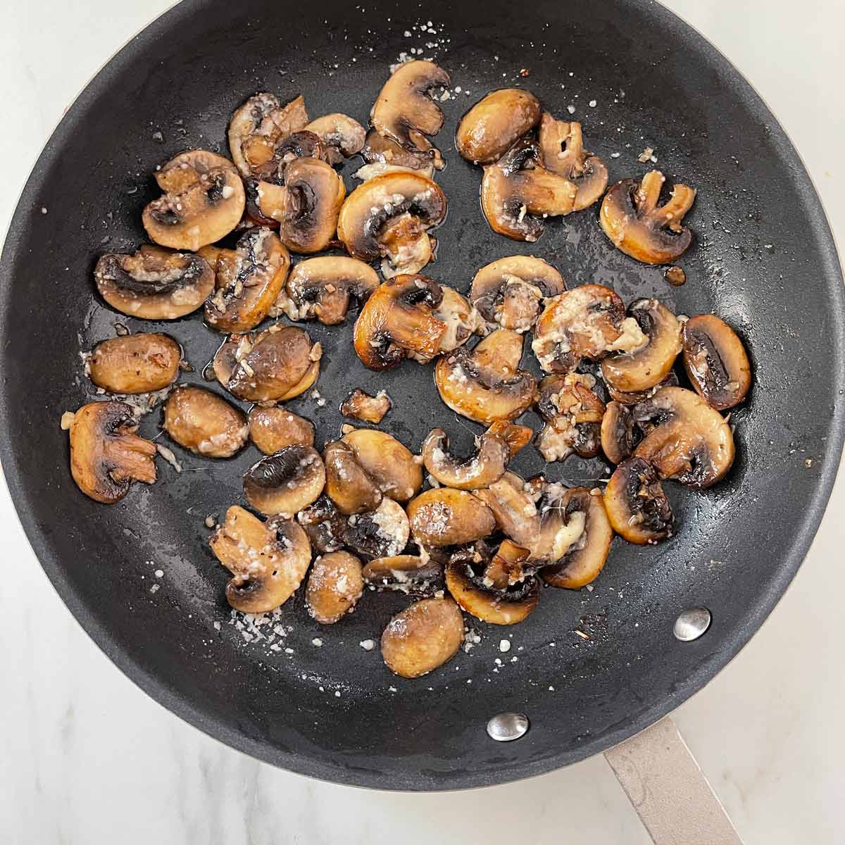 Fully cooked mushrooms in skilet.