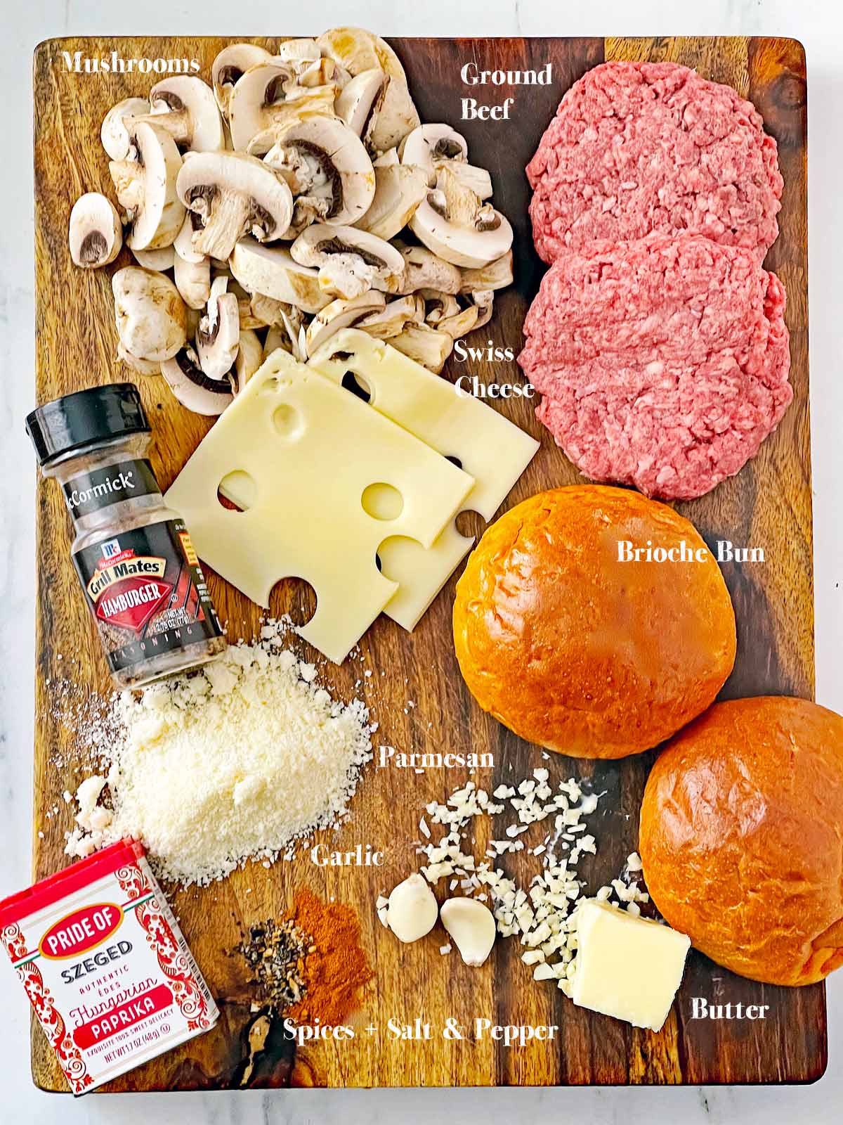 Cutting board with all the ingredients for Red Robin Mushroom Swiss Burger Recipe.