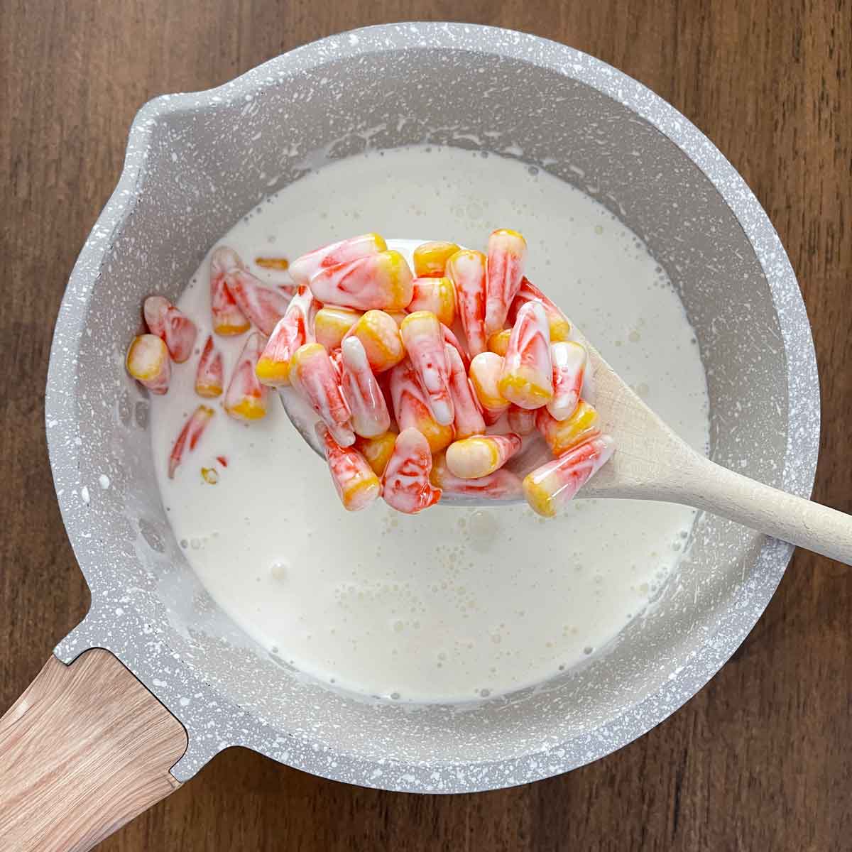 Candy corn and cream in saucepan.