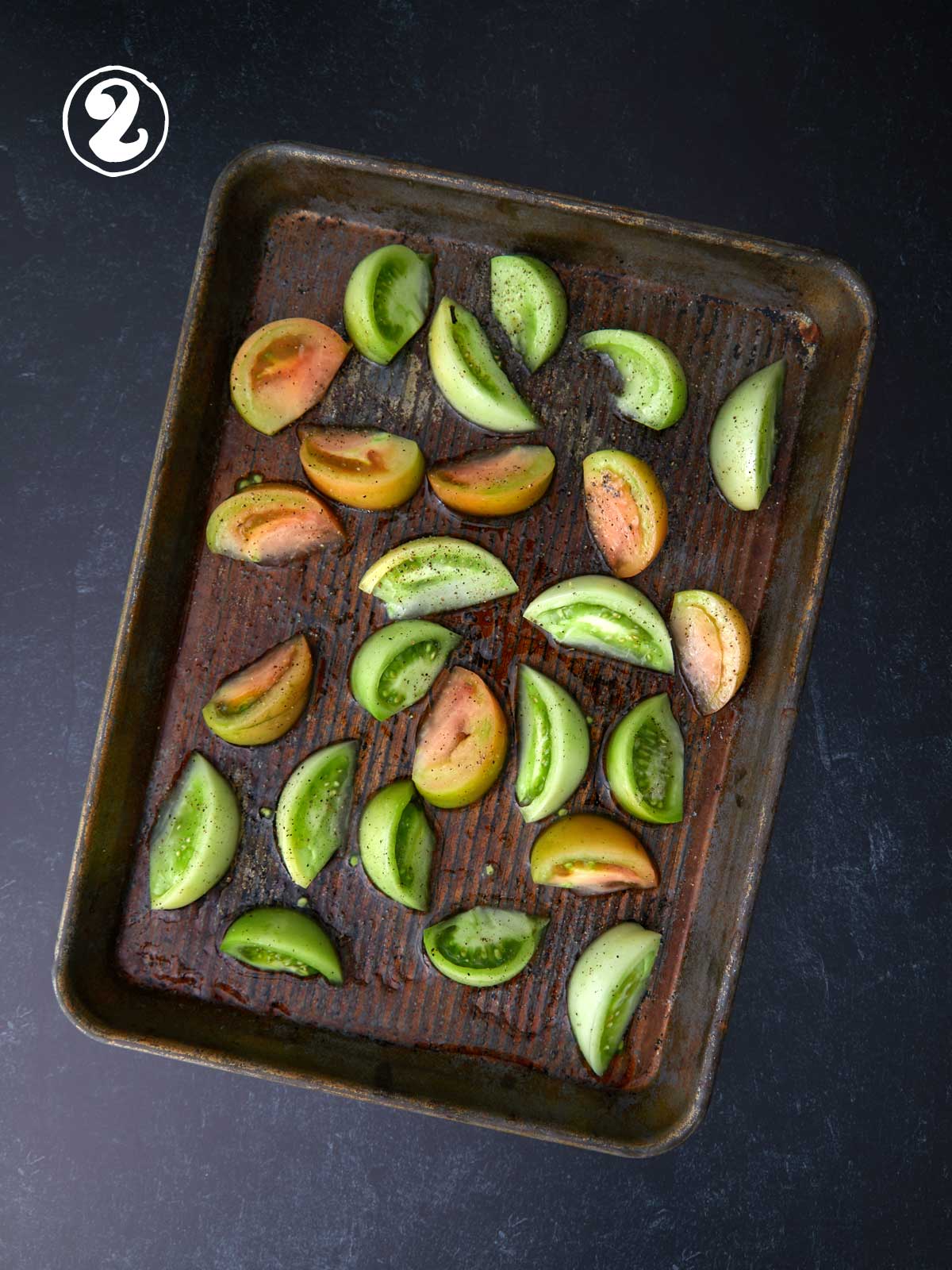 Baking sheet with sliced green tomatoes.