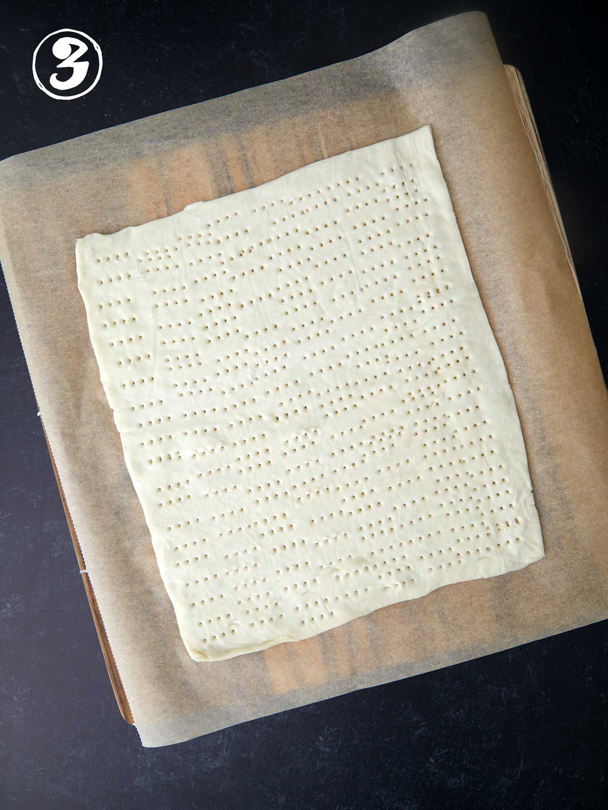 A parchment paper with a dough for green tomato tart.
