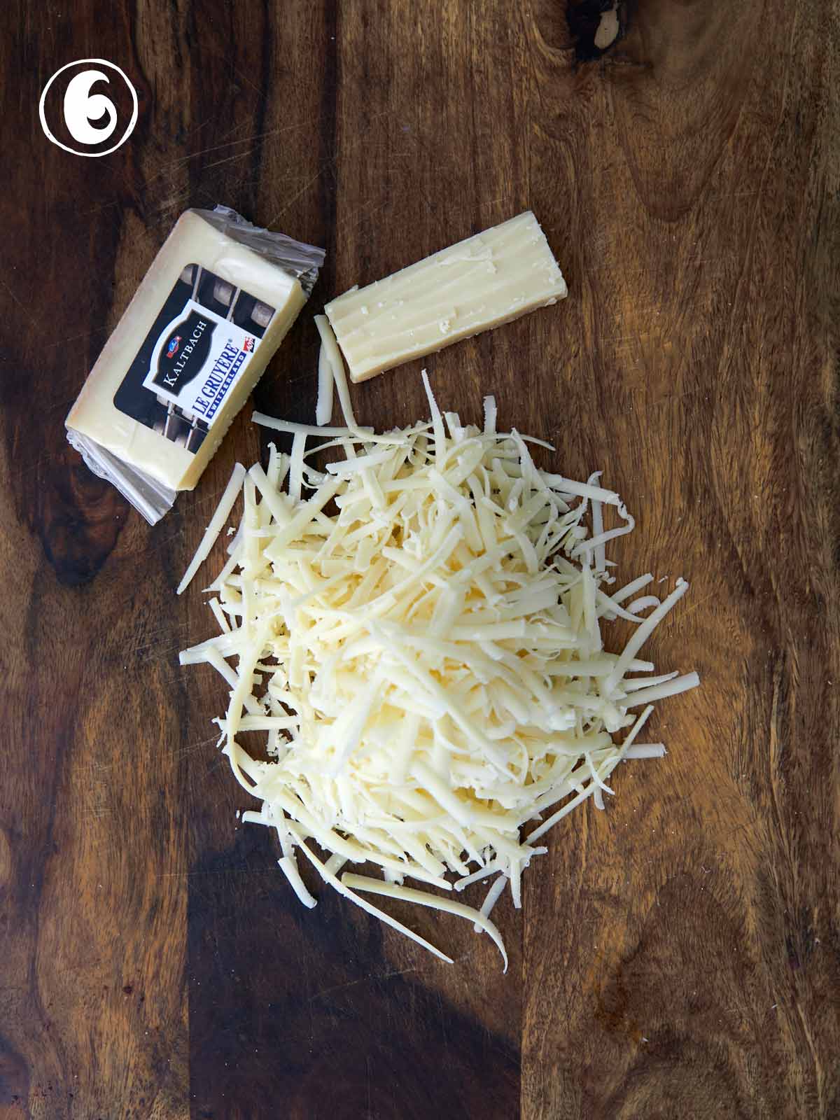 Gruyère cheese on a wooden cutting board.