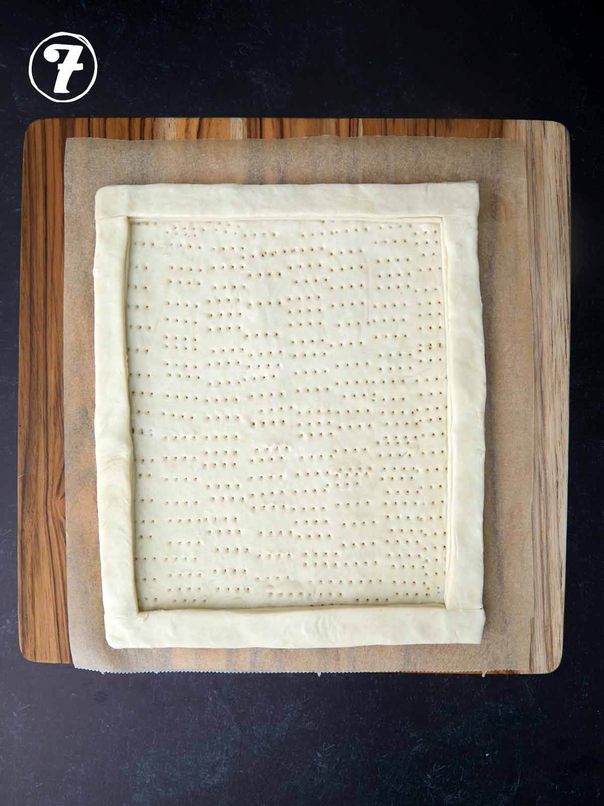 A square of green tomato tart pastry dough on a cutting board.