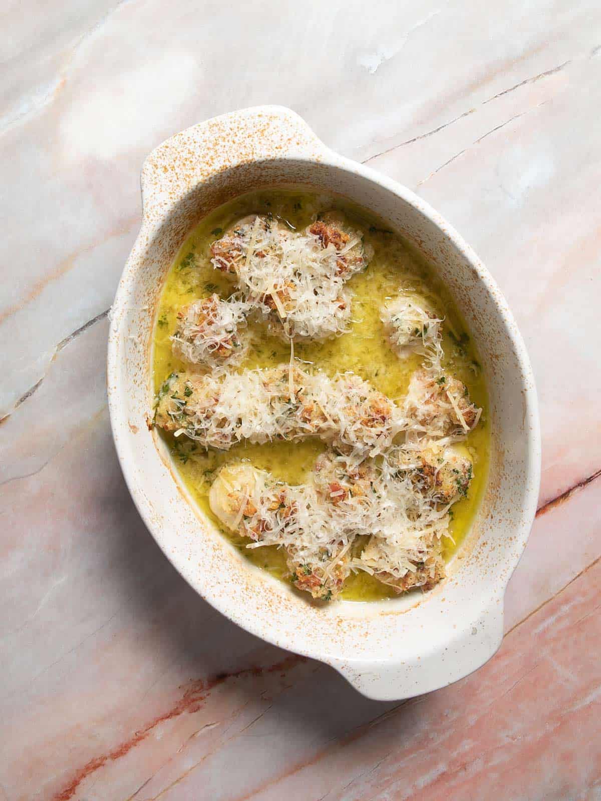 Baking dish with scallops gratin and Parmesan cheese.