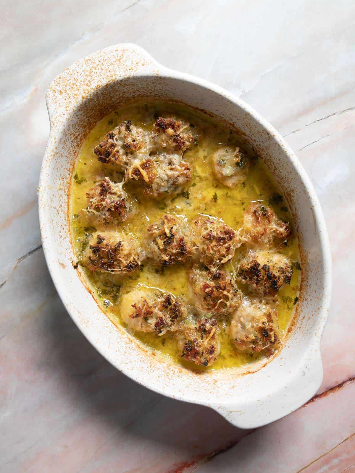 Broiled scallops gratin with golden brown bread crumbs on top.