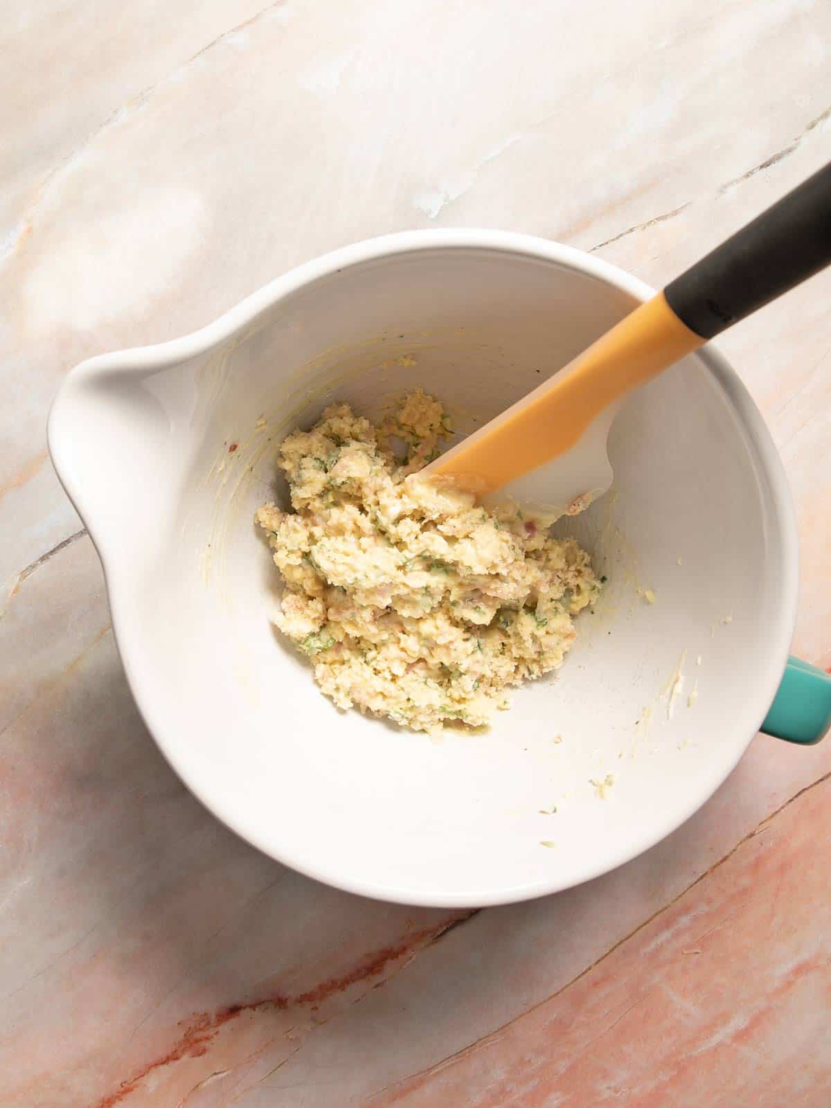 Mixing bowl with spatula scraping down the sides.