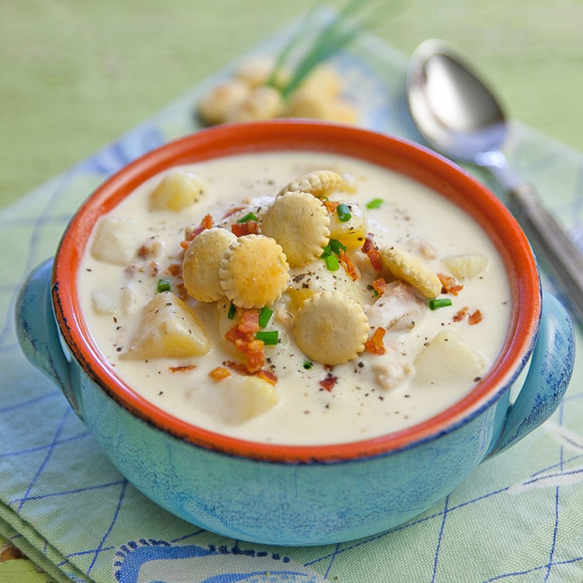 Bowl of clam chowder with oyster crackers.