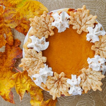 Pie made of butternut squash and apples with leaf-shaped crust decorations.
