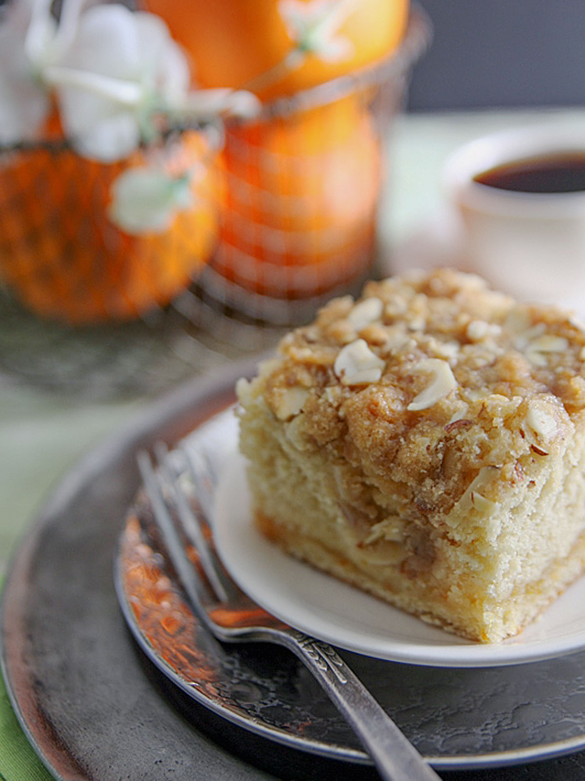 Orange Marmalade Coffee Cake with streusel topping and fresh oranges in the background.
