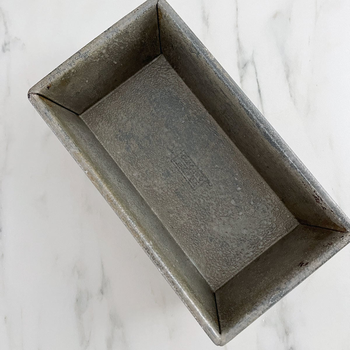 Metal loaf pan sprayed with baking spray.
