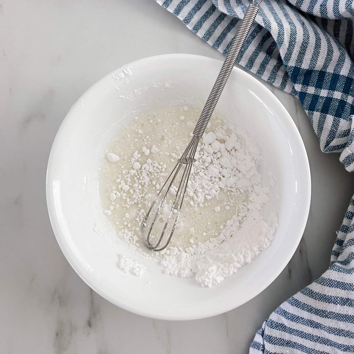 Small white bowl with glaze ingredients being mixed together.