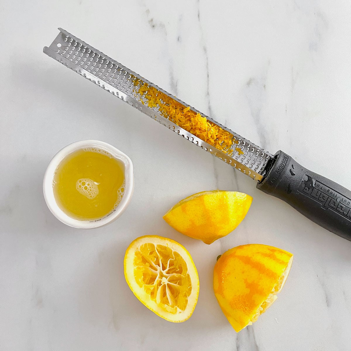 Micro-planer with lemon zest and squeezed lemons and juice.