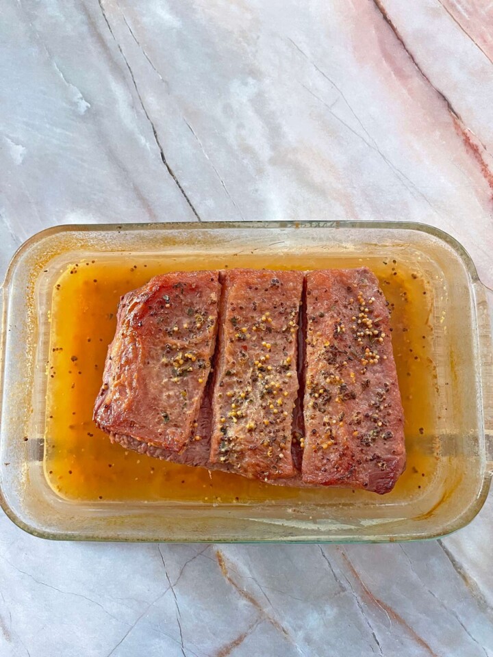 Cooked corned beef in baking dish.