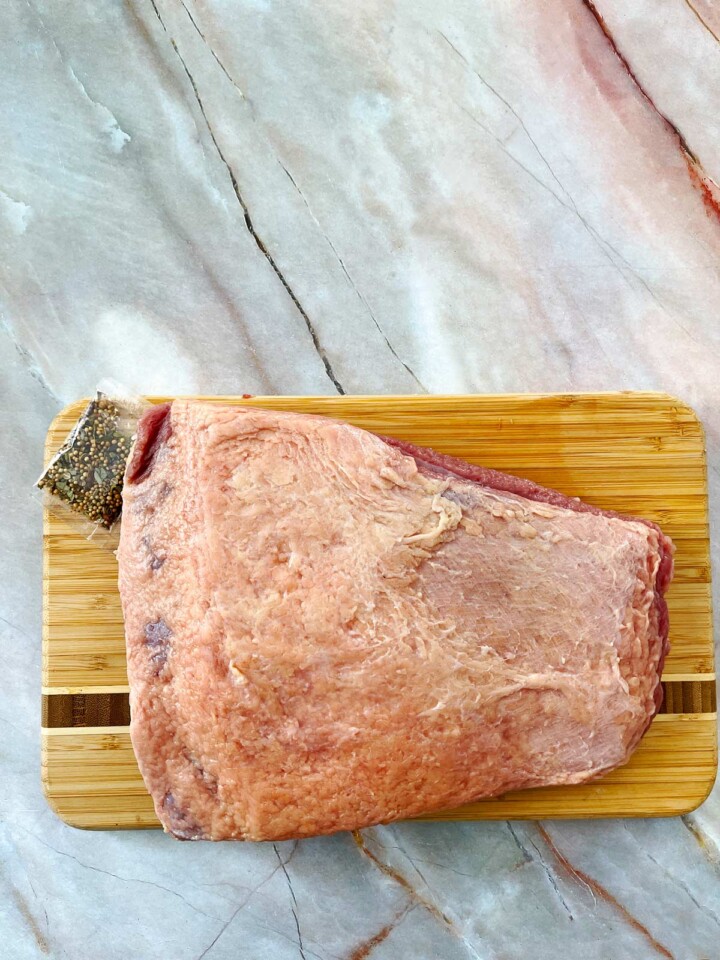 Fat cap side of corned beef with spice packet.