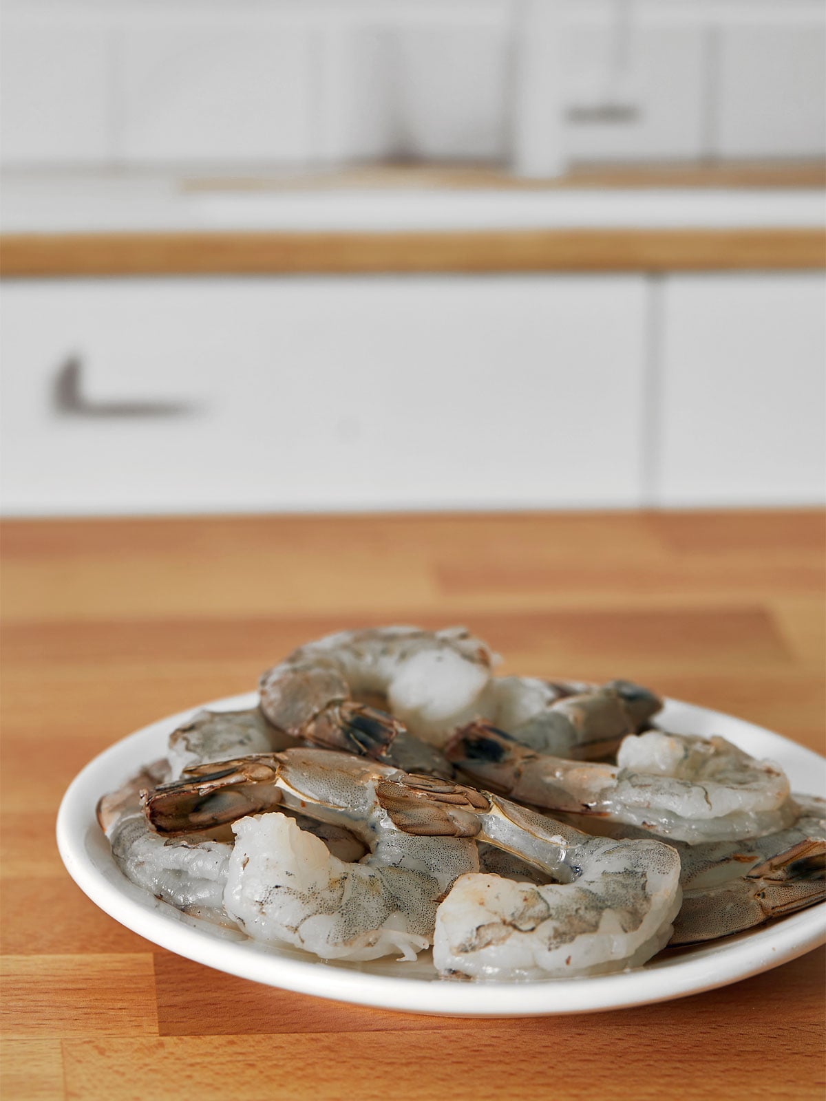 A plate with clean and deveind shrimp for roasted shrimp cocktail.
