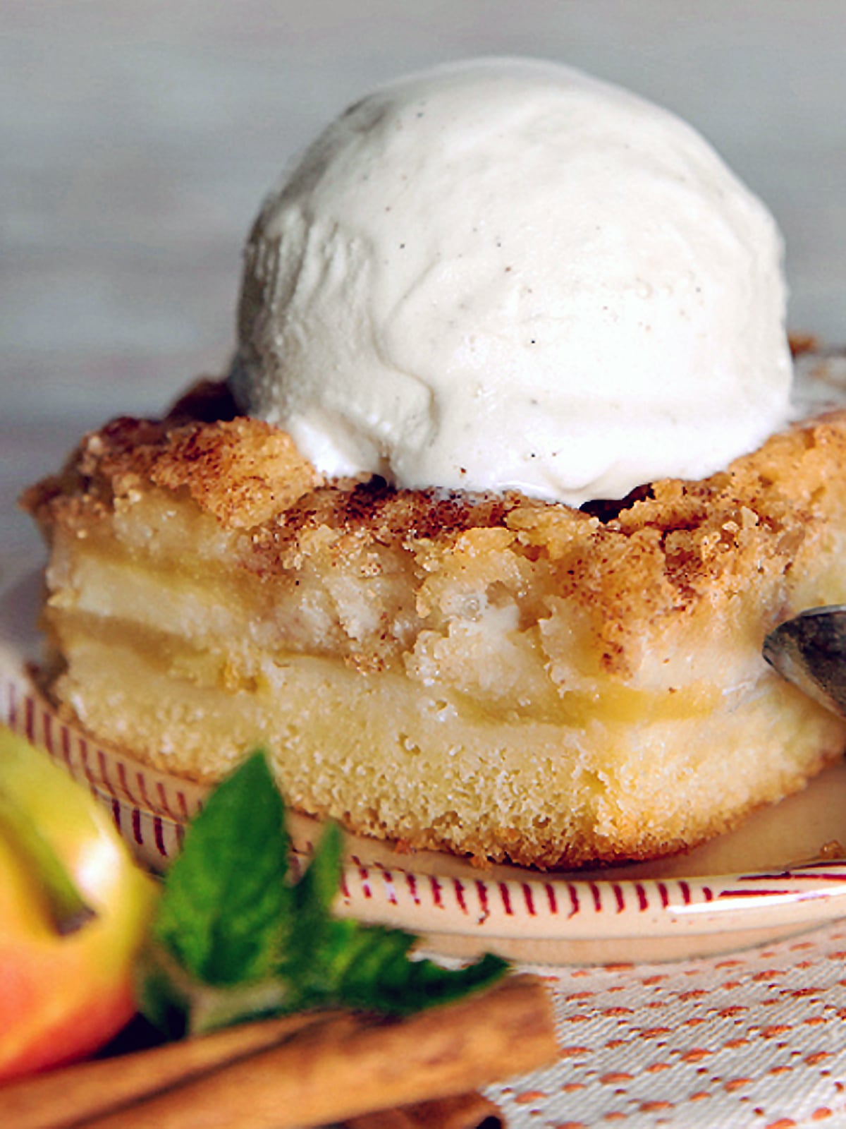 A slab of German apple cake with vanilla ice cream.