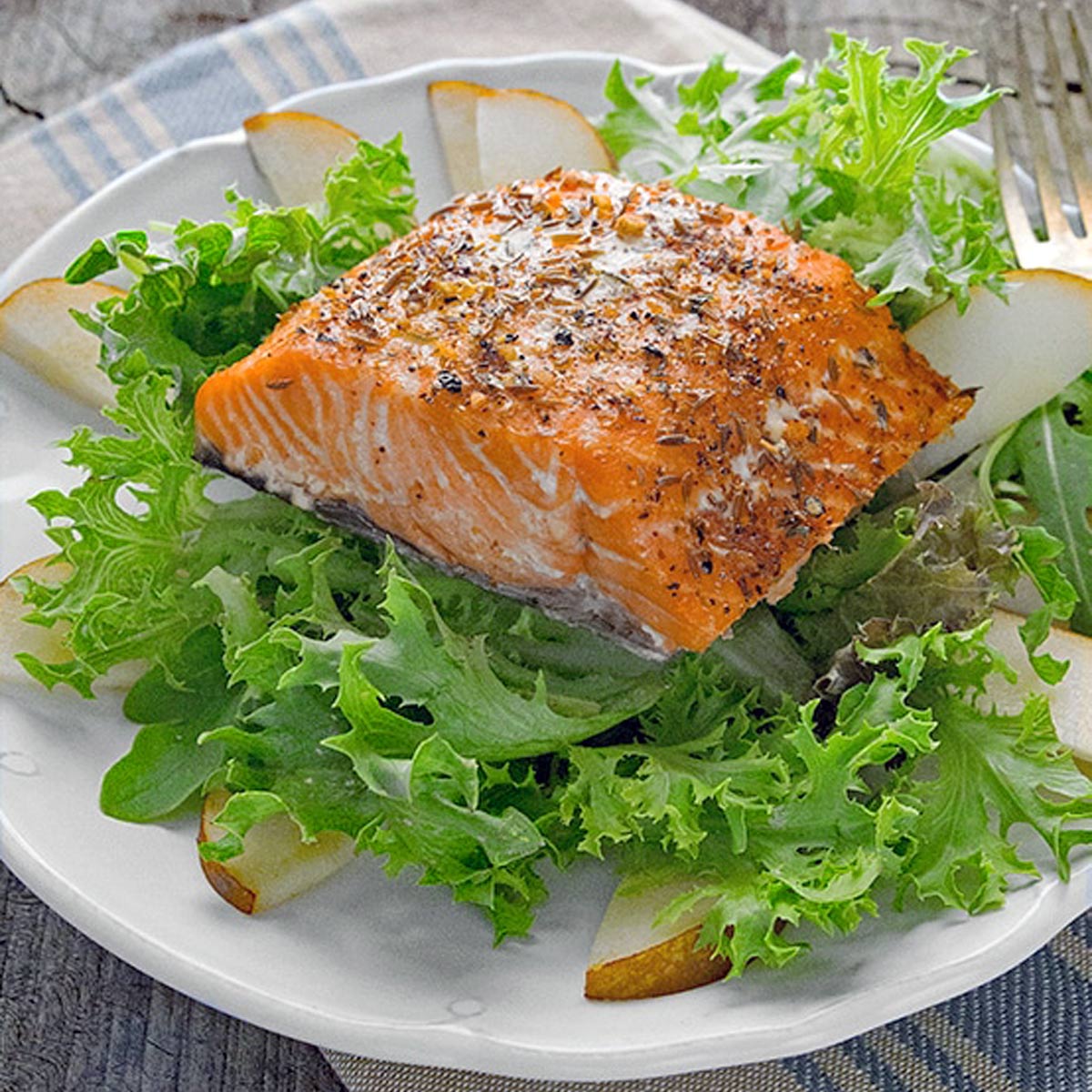 Steelhead on a bed of lettuce with sliced pears.