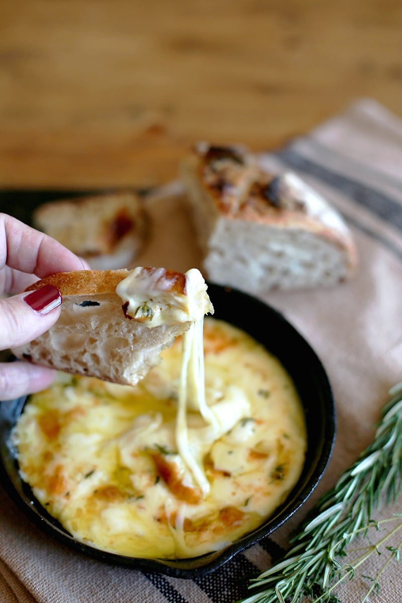 Baked Fontina on crusty bread with long cheese pull.