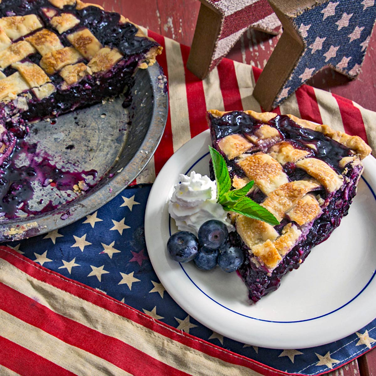 Blueberry pie slice with patriotic-themed table setting.