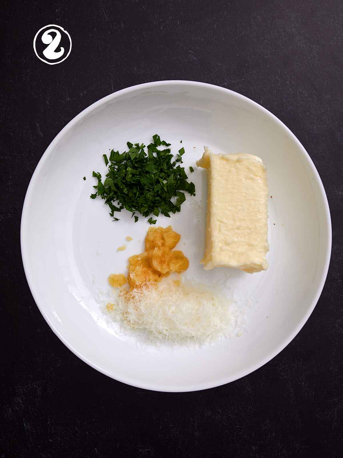 Bowl with butter, parsley, garlic, and Parmesan cheese.