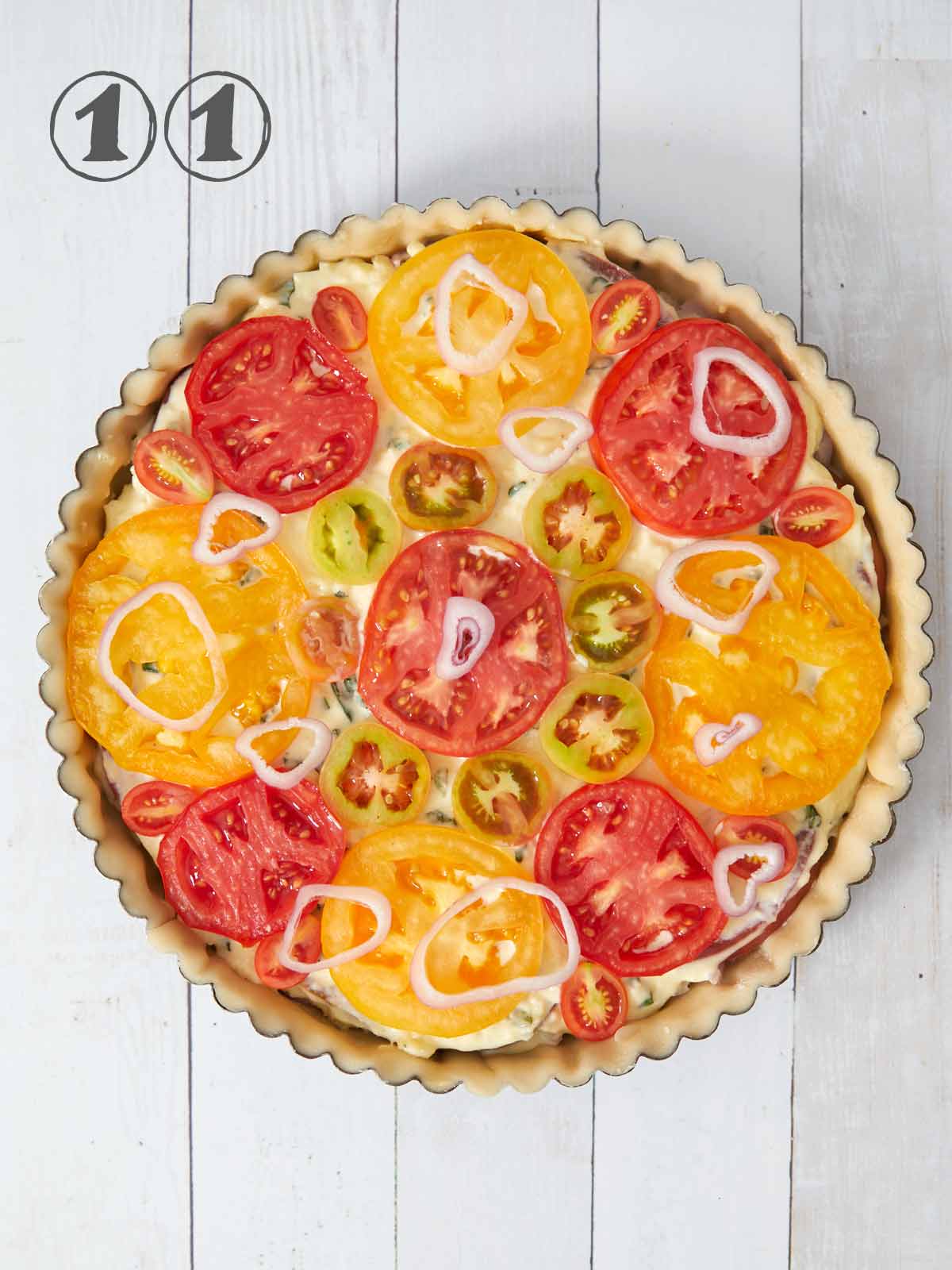 Final layer of tomatoes placed on top of cheese mixture with shallot slices.