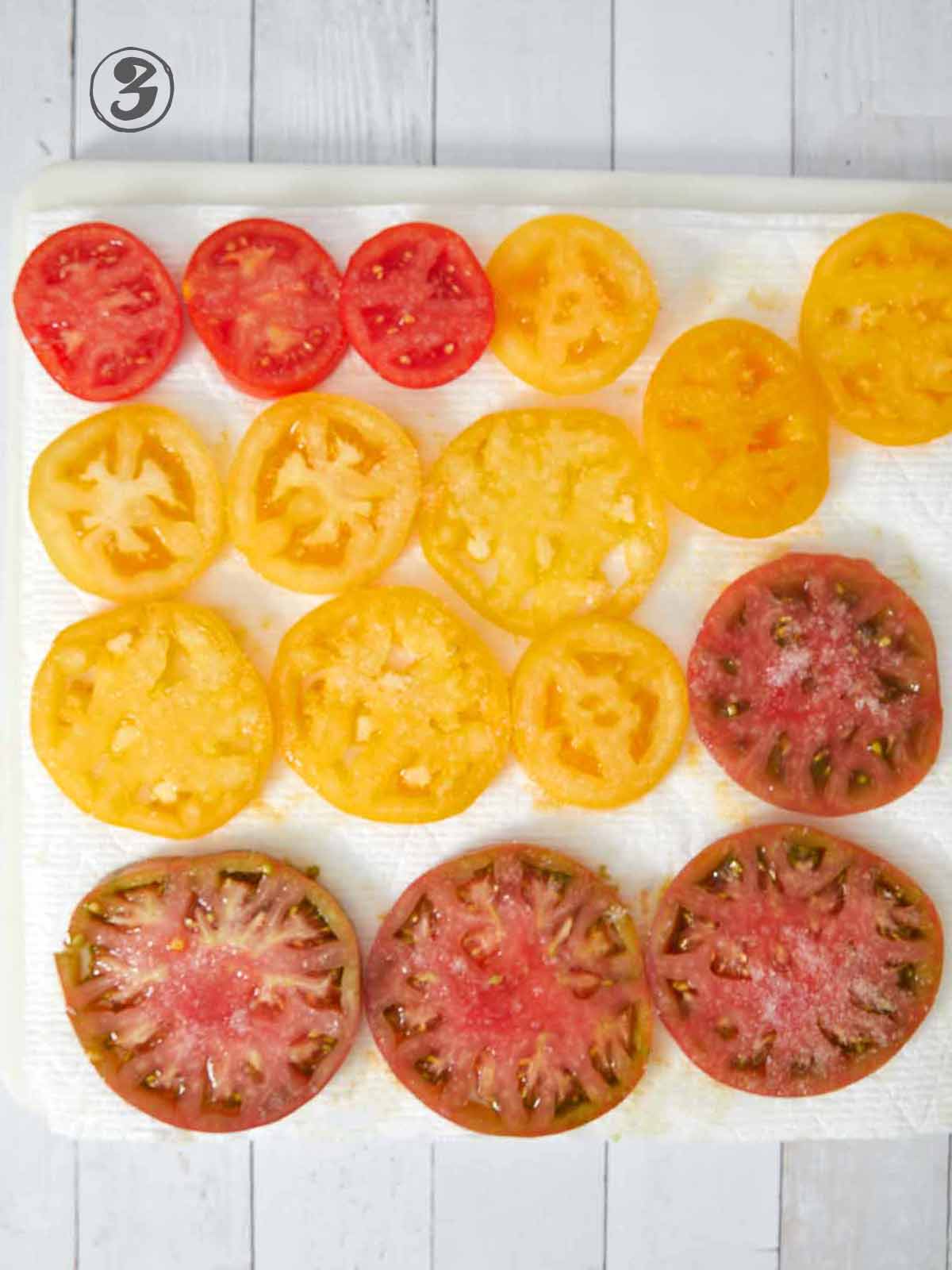 Sliced tomatoes on paper towels.