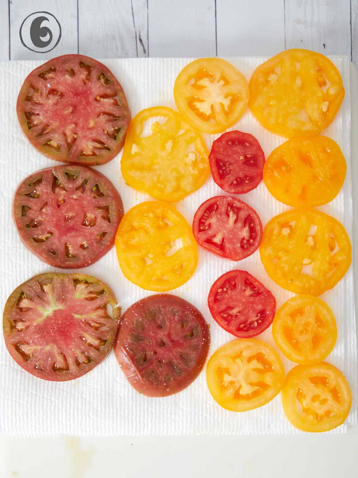 Sliced tomatoes laid out on paper towels.