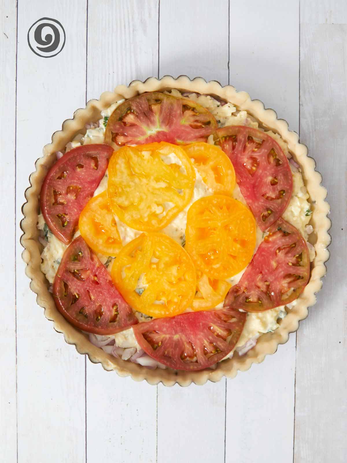 Tomatoes arranged on top of cheese mixture.