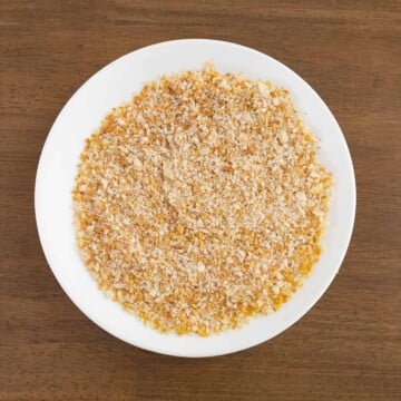 Plate with ground macadamia nuts and panko bread crumbs mixed together.