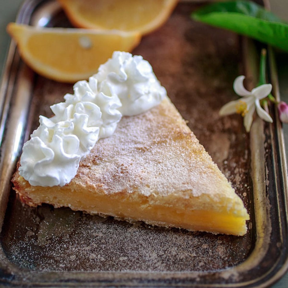 Slice of Meyer lemon tart on baking sheet.