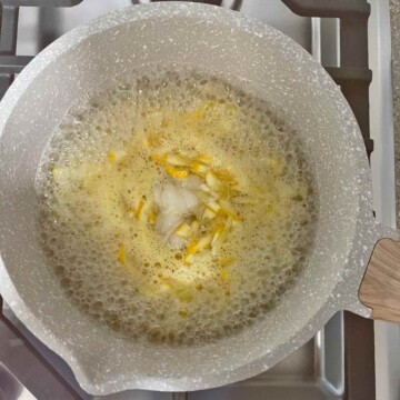 Lemons, sugar and water boiling on stove with sachet of seeds.