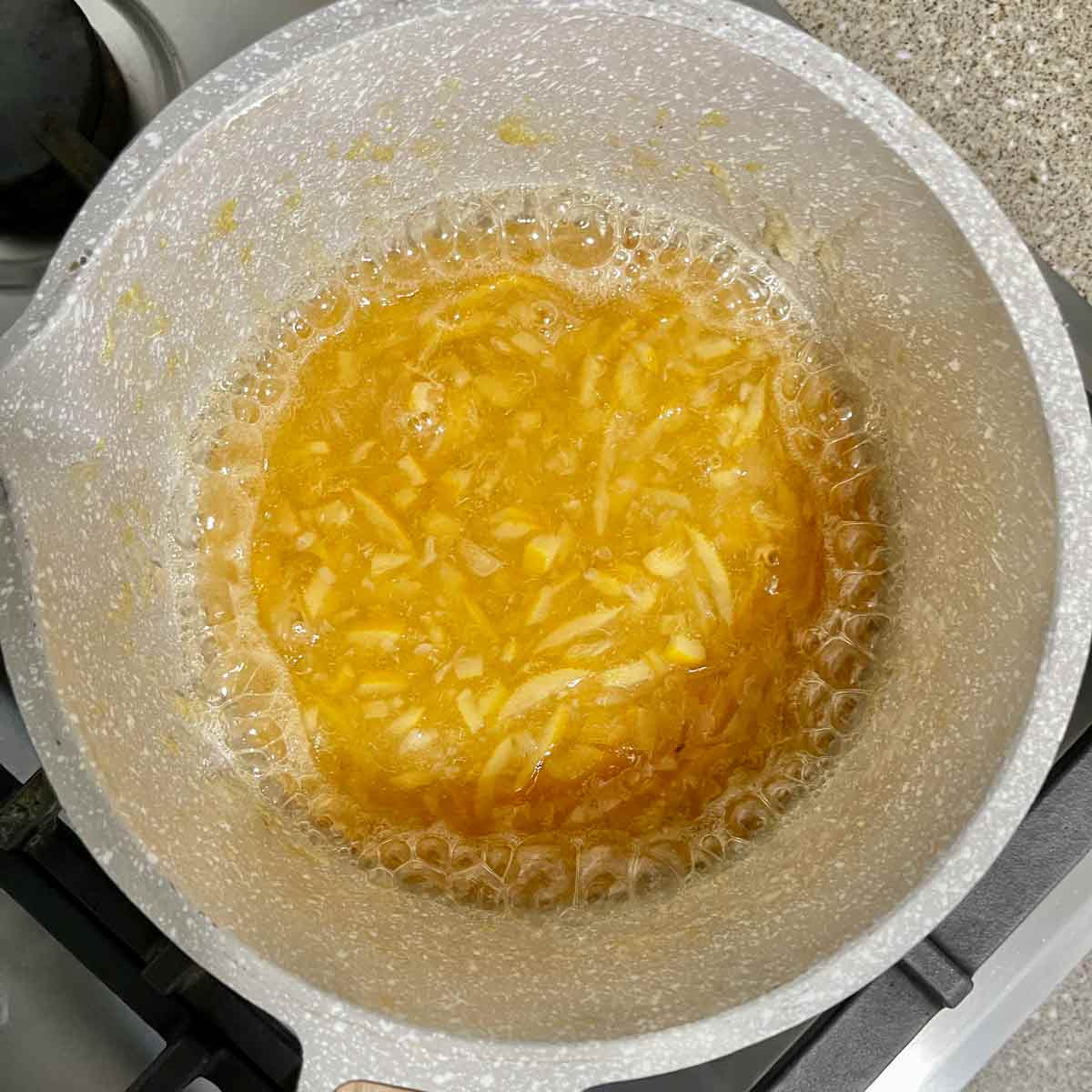 Lid removed from pot and marmalade is thickened.