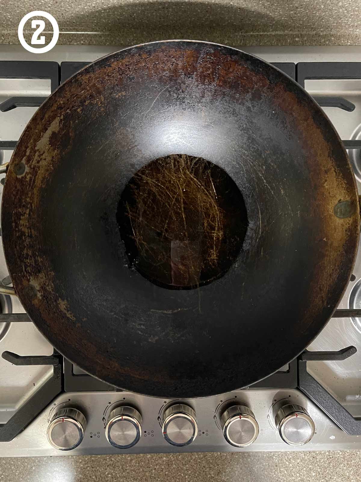 A large wokon top of a stove, with oil.