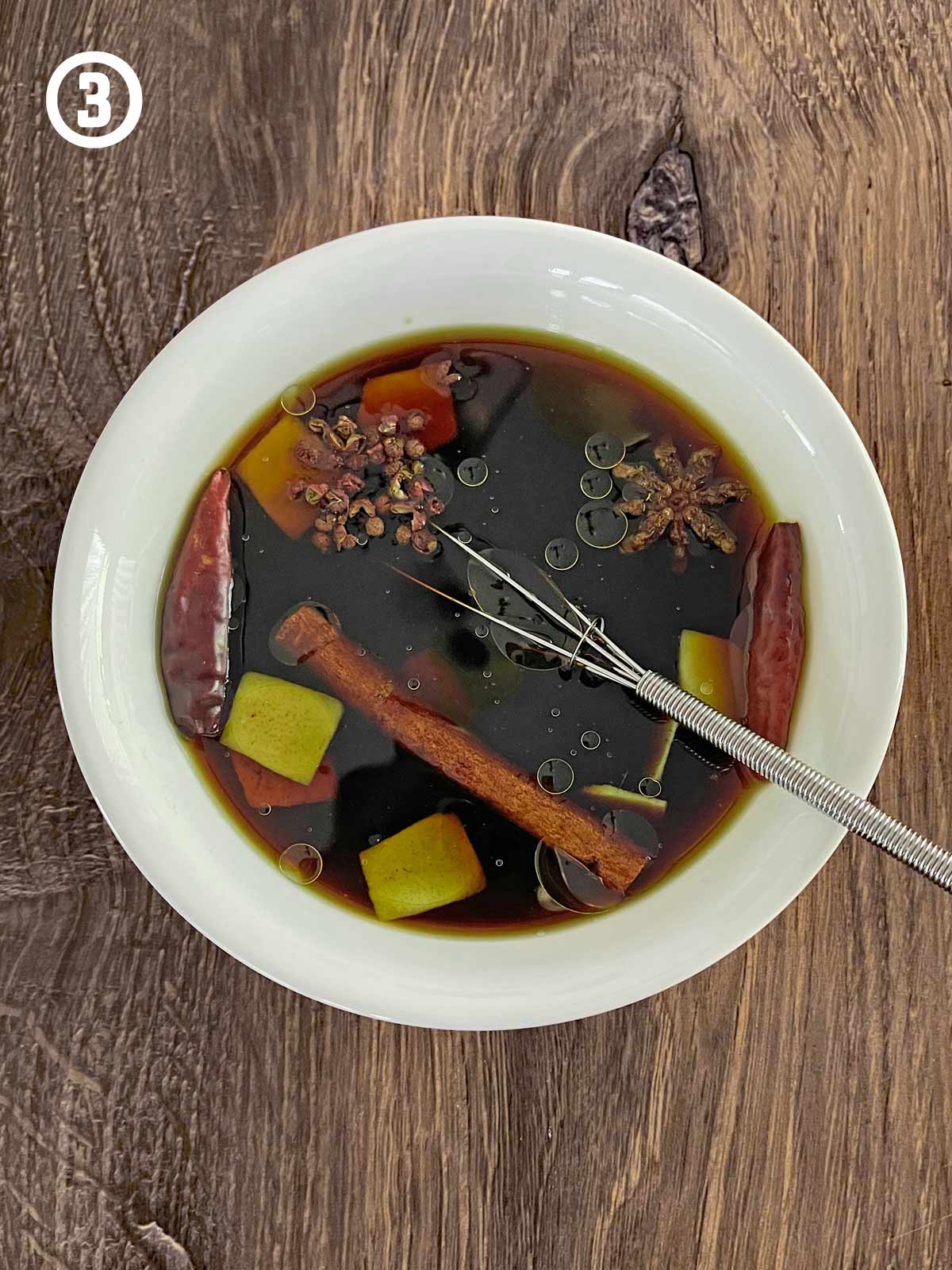 A bowl of sauce ingredients with a spoon in it.