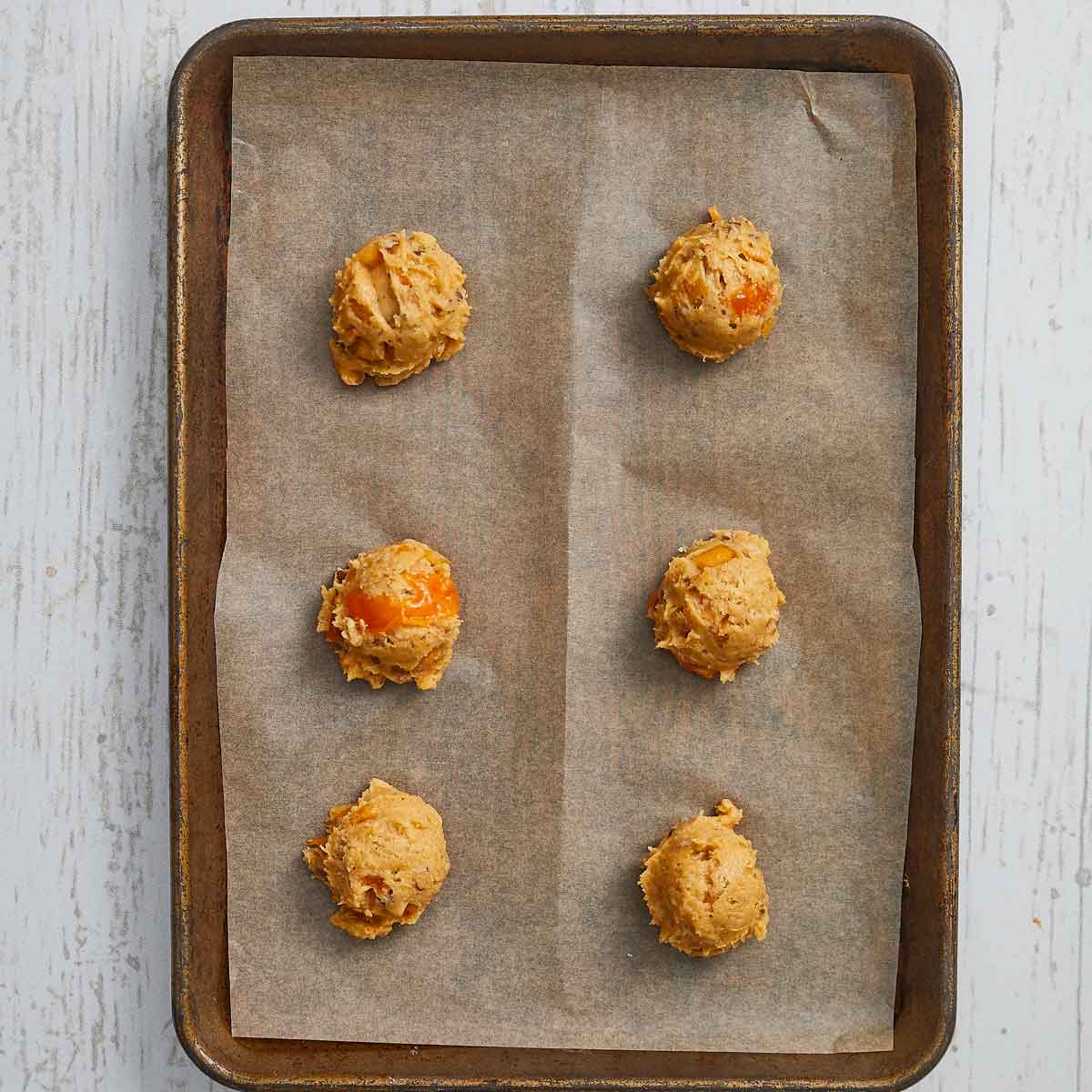 Baking sheet with 6 cookies scooped on.
