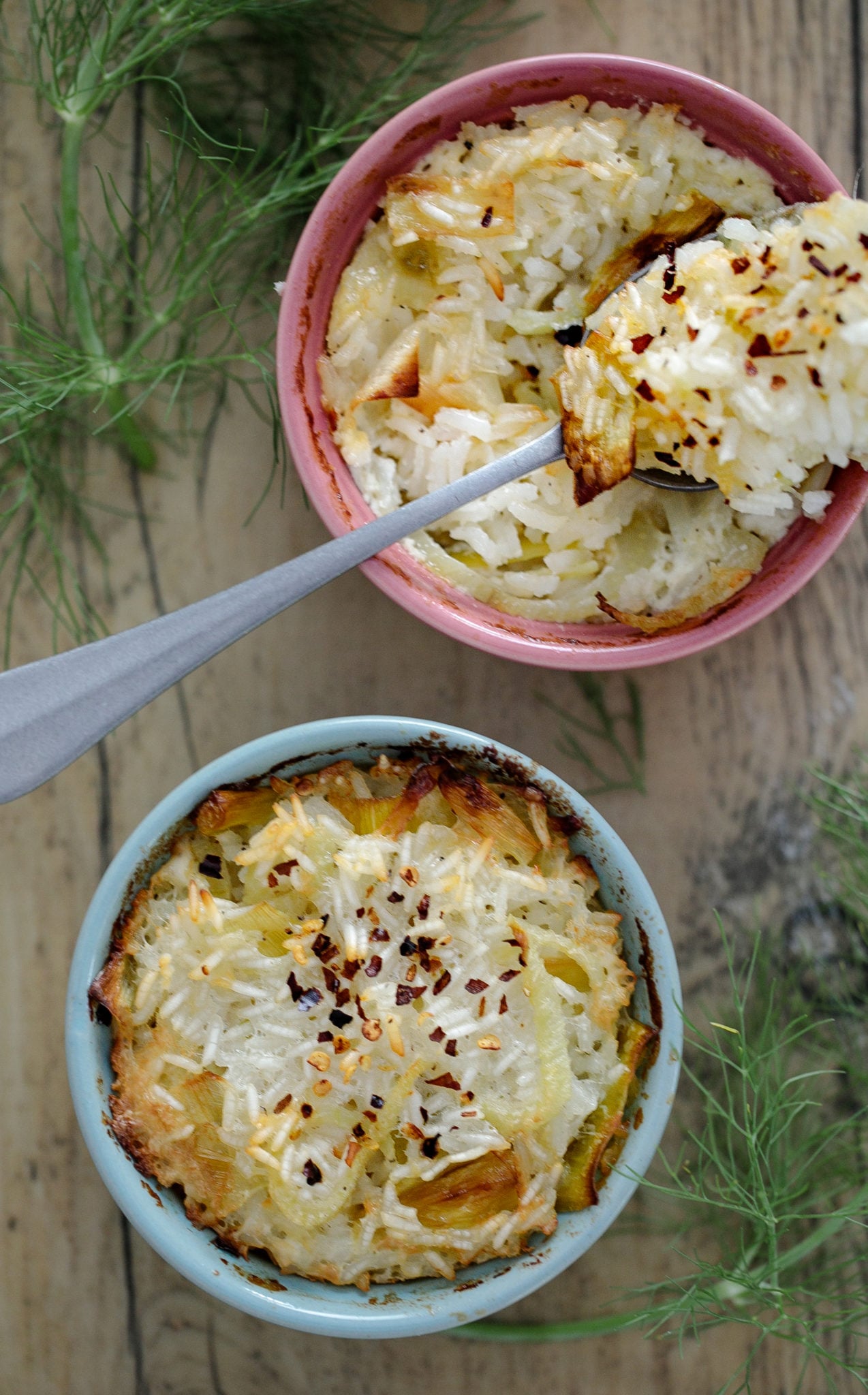 Ramekins with rice fennel casserole and spoon.
