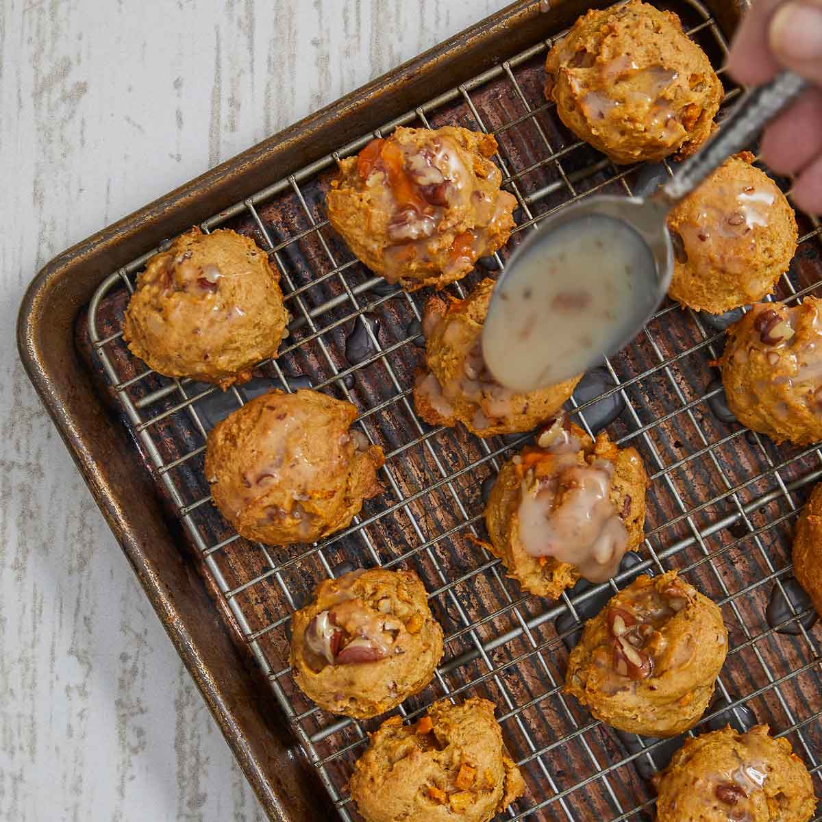 Glaze being oured over the cookies with a spoon.