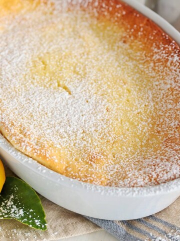 Fully baked lemon souffle cake with powdered sugar sprinkled on.