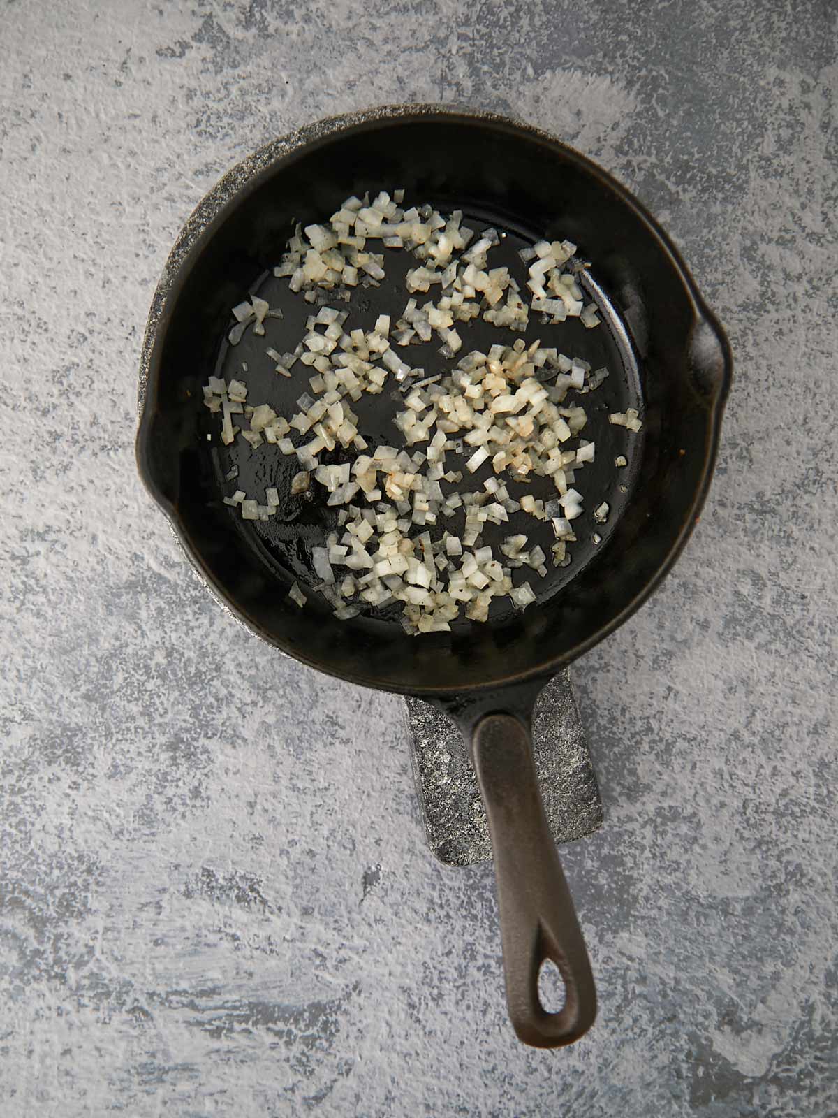 Onions cooking in cast iron skillet.