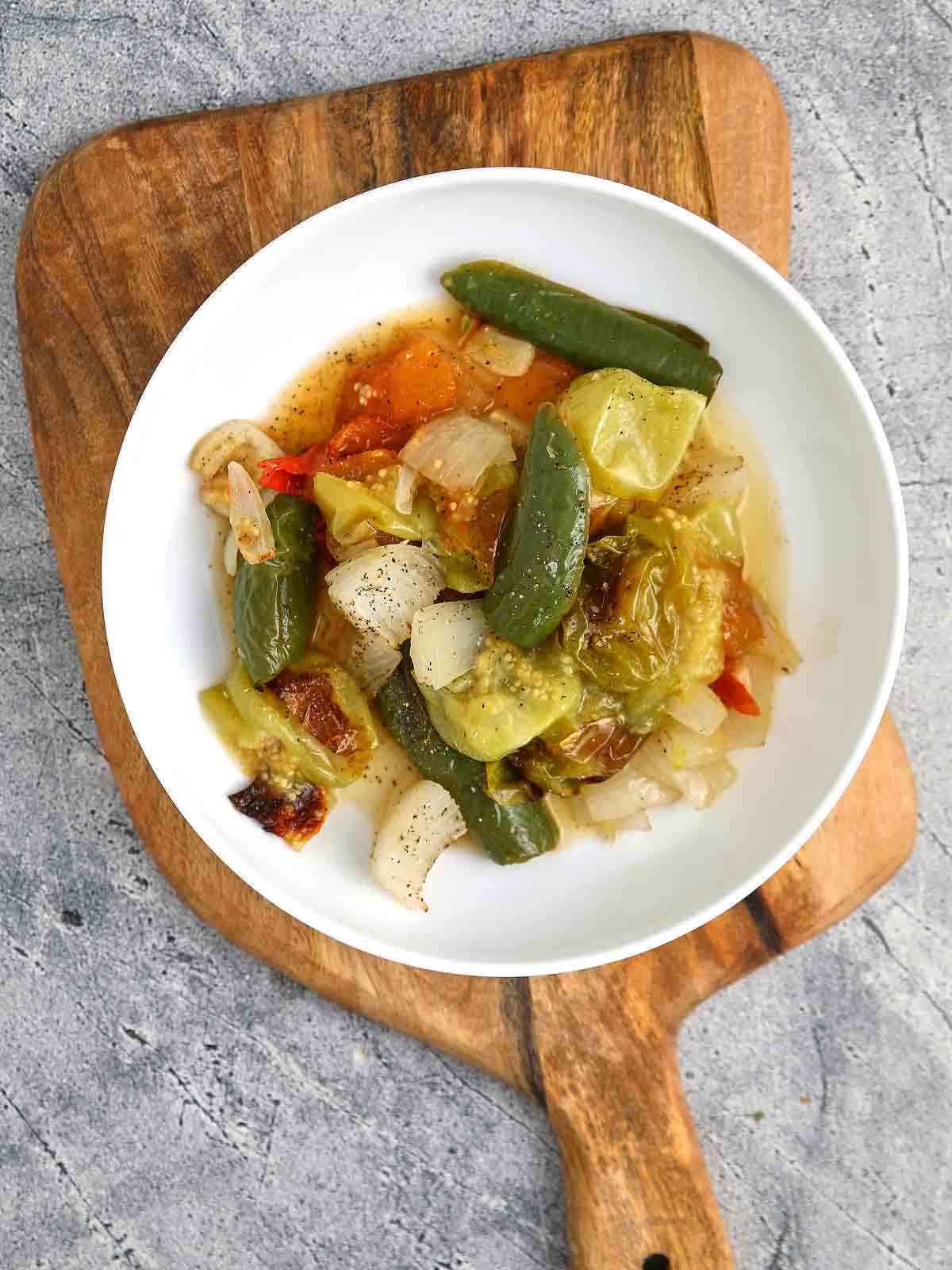 Large bowl with the raiscted vegetables and the juice that was given off as they roasted.