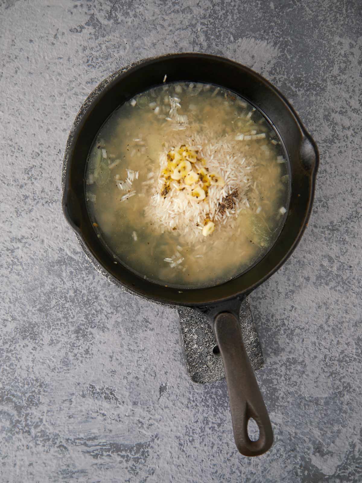 All ingredients in skillet to cook rice except the chicken.