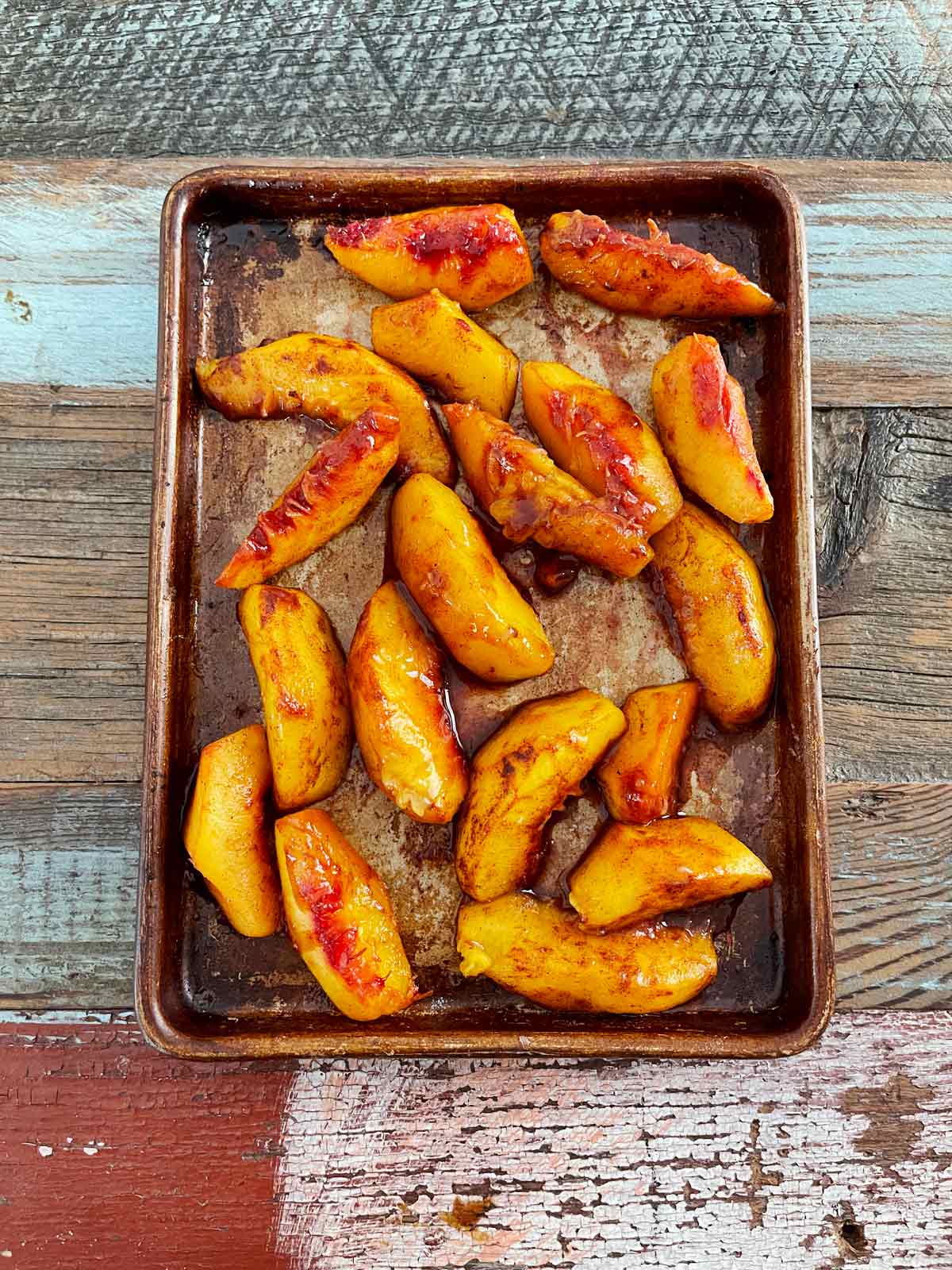 Baking sheet with roasted sliced peaches.